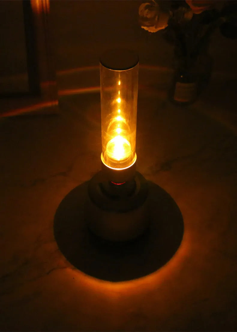 White silver candlelight Bluetooth speaker and night light on a table, showing modern cylindrical design.