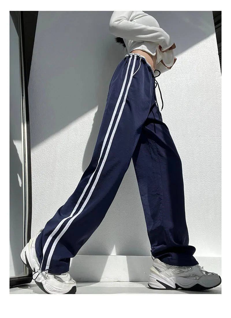 Navy blue loose straight-leg trousers with contrast detail, shown on a hanger.