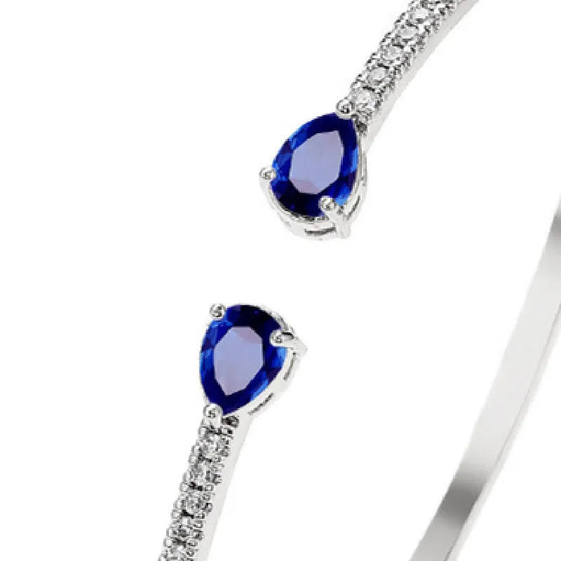 Copper bracelet with inlaid zircon stones in a simple style, shown in white and blue colour options.