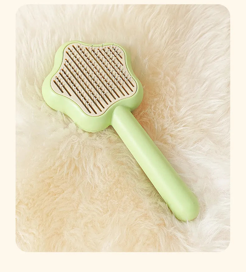 Green cat comb with stainless steel needles and self-cleaning magic wand function on white background