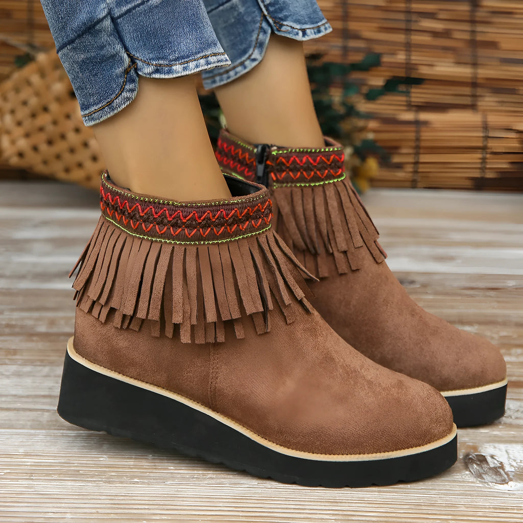 Women's dark brown suede ankle booties with a wedge heel, side zipper, and tassel detail