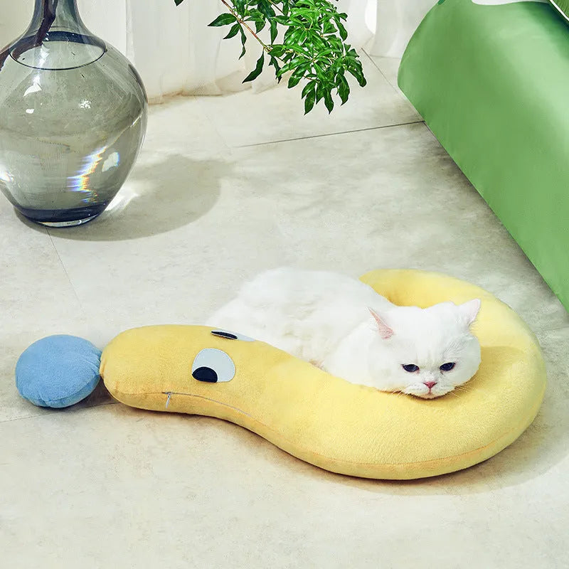 Blue rectangular pet sleeping cushion for cats and dogs on a wooden floor.