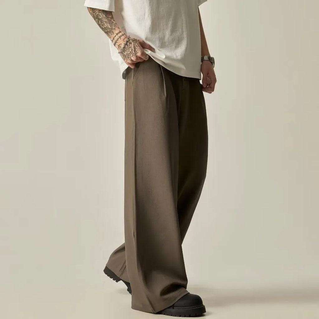 Men's solid black casual straight-leg trousers with a wide-leg fit and button fly on a neutral background.