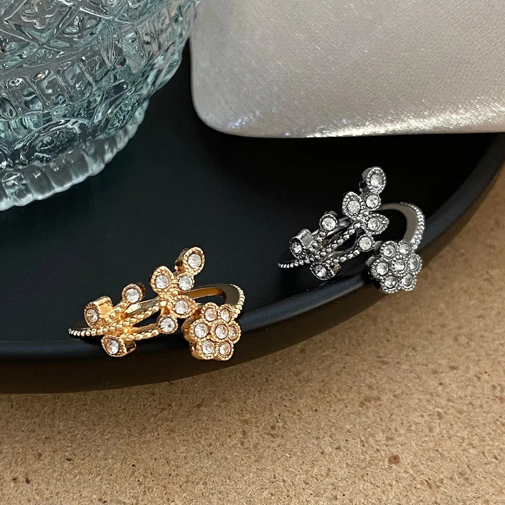 Women's open mouth copper ring with diamond-textured flower and leaves design in gold or white finish.