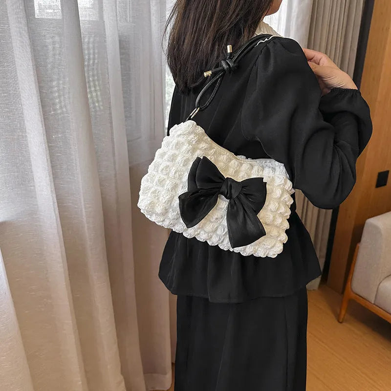 Women's horizontal square canvas handbag with single shoulder strap in black colour showing sandwich pocket detail