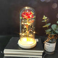 LED illuminated glass bouquet with pink silk roses and warm white lighting on wooden table