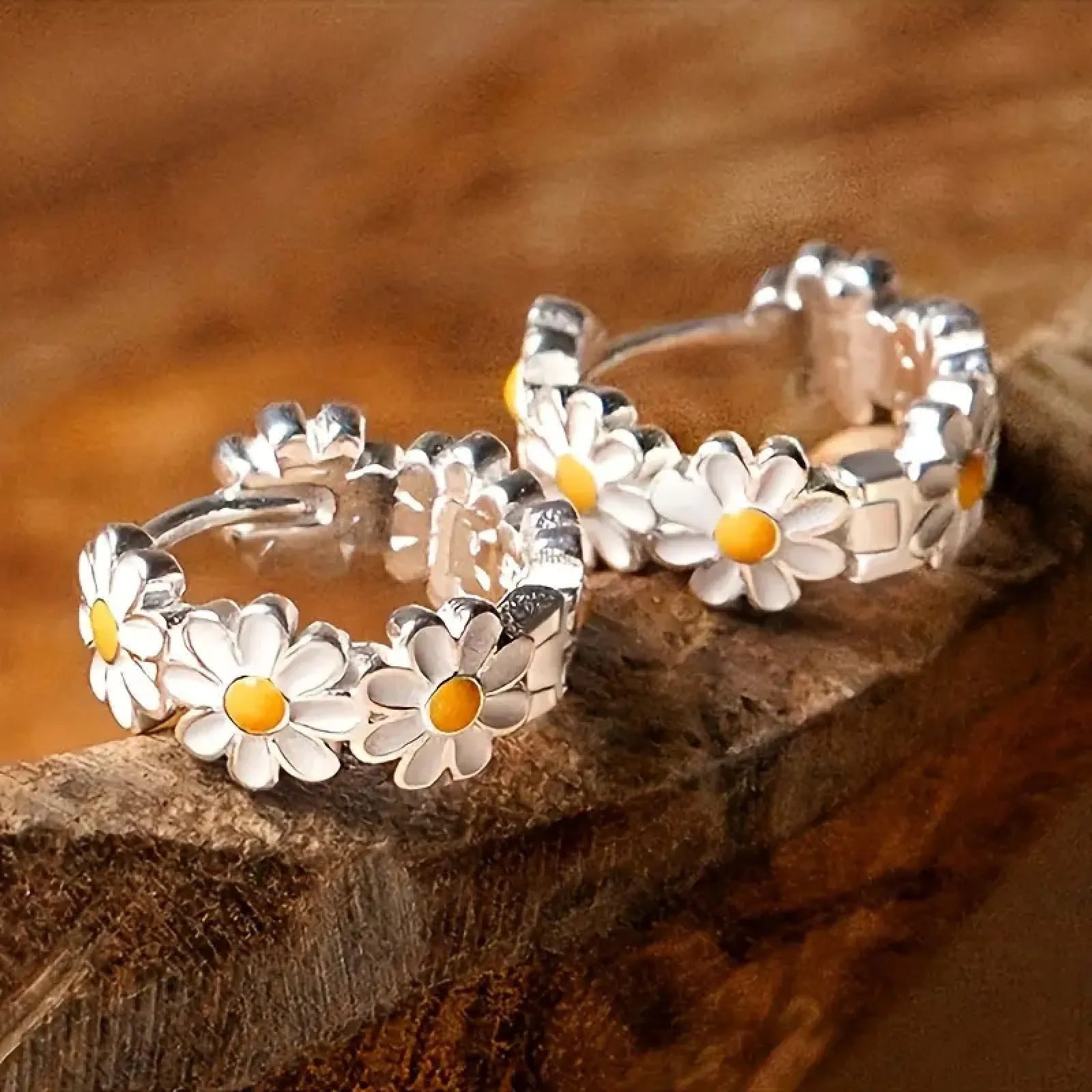 A pair of white daisy flower ring earrings with platinum inlaid gemstones on a copper base.