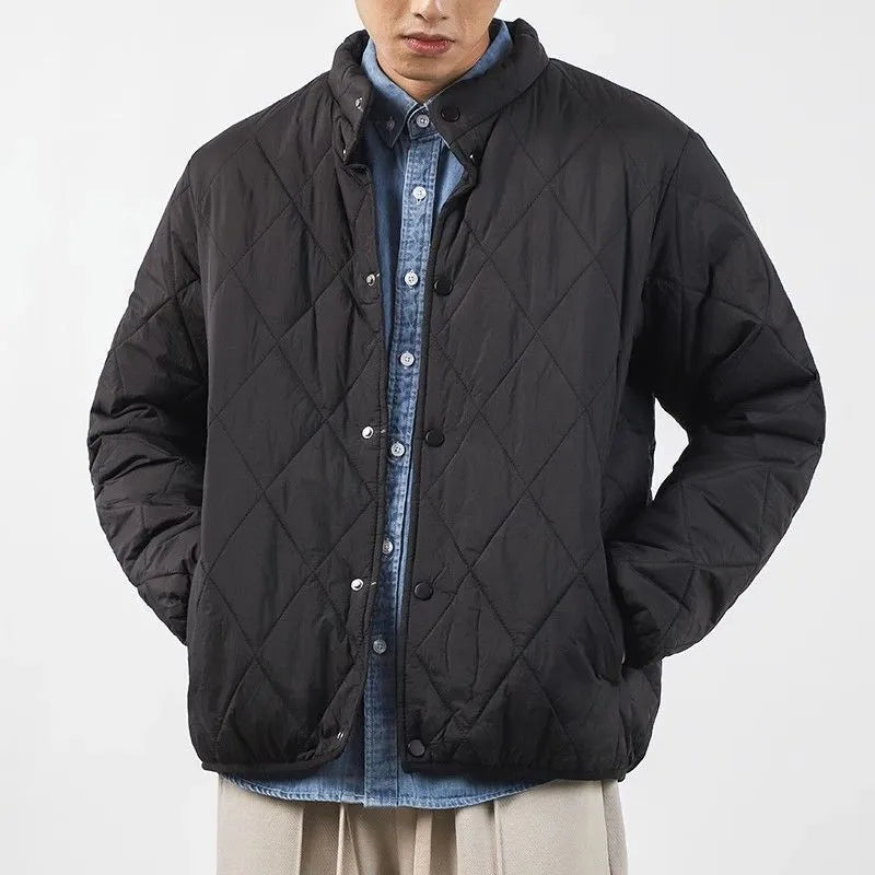 Men's black elongated winter jacket with diamond quilted pattern on a mannequin.