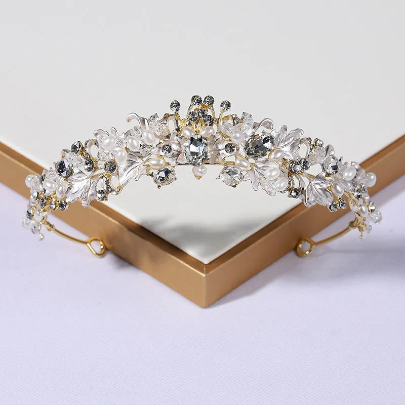 Gold metal alloy crown headdress with a white pearl-like decoration for women.