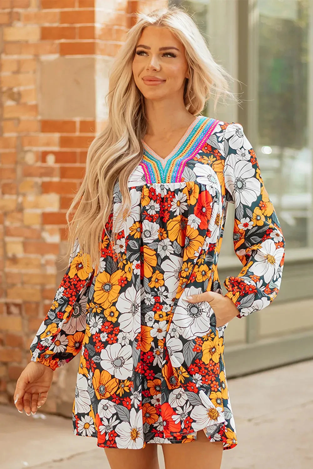 Orange floral and striped patterned mini dress with a lace-trimmed V-neck collar and long sleeves.