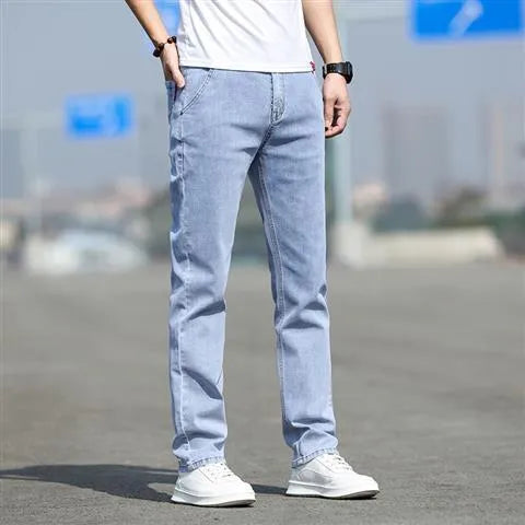 Men's smoky grey low waist straight leg jeans with a zipper fly, shown on a hanger.
