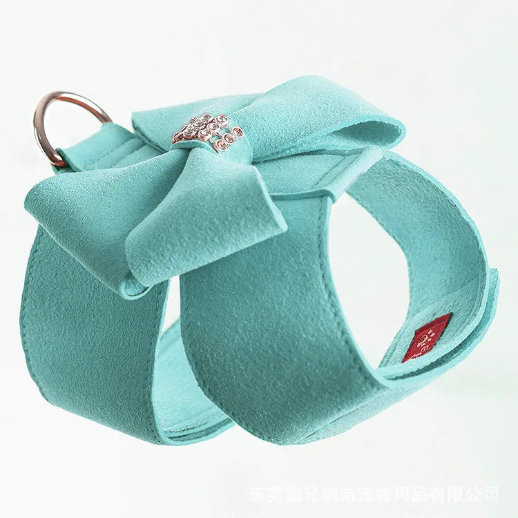 Pink microfiber dog chest strap with a large white bowknot, showing adjustment buckle and D-ring.