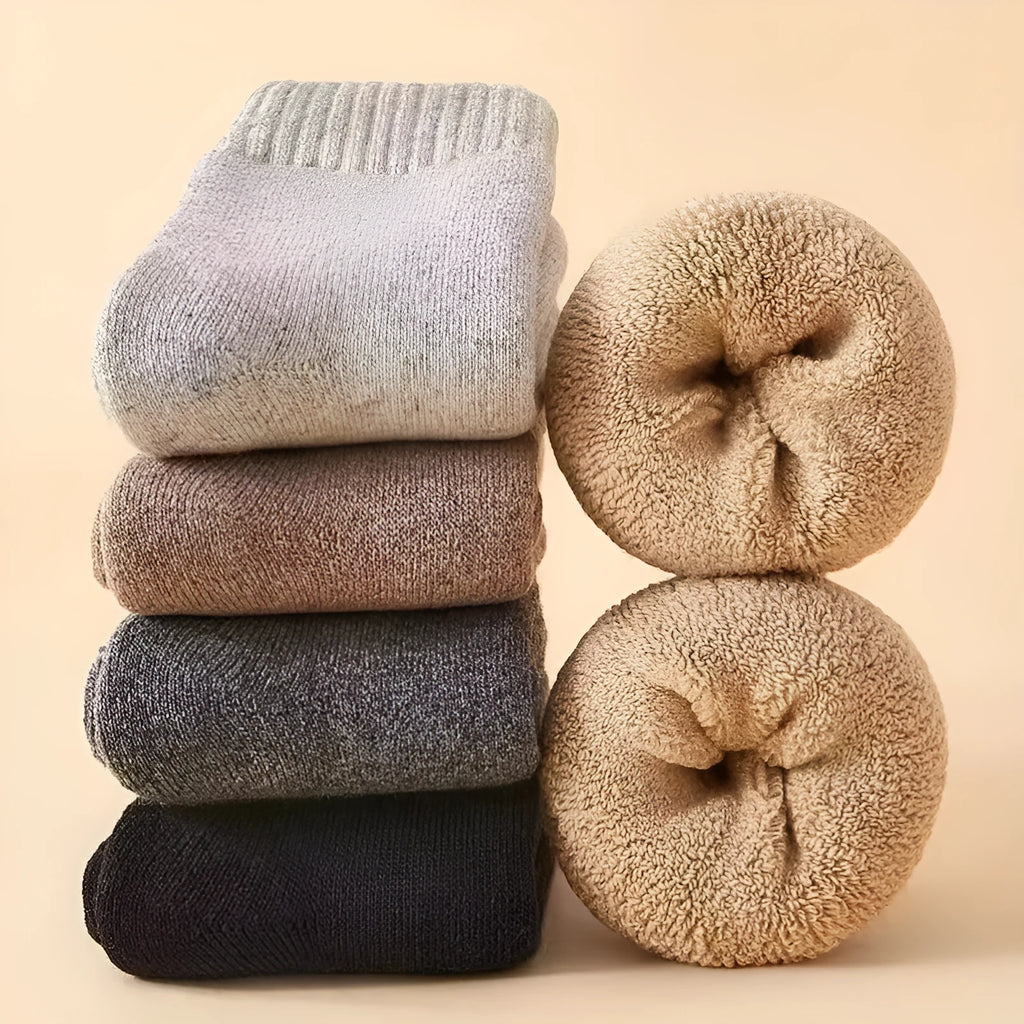 Pair of thick wool winter socks with a merino midsole in a neutral colour on a presentation box.