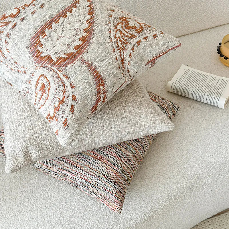American-style amber jacquard pillow cover with paisley plant pattern, shown on a sofa.