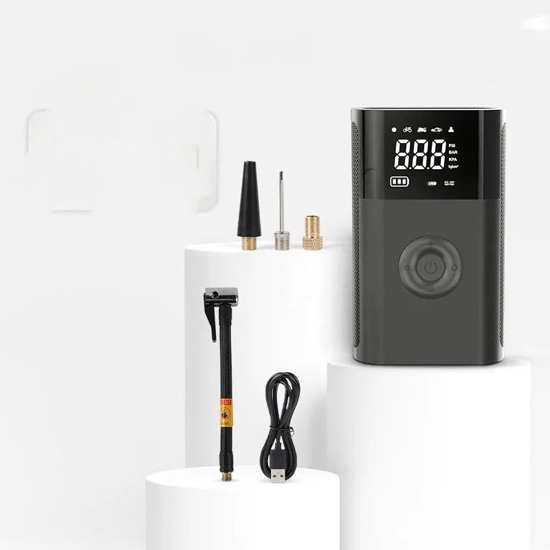 Handheld wireless digital display car tyre air pump with LED light and attachments on a grey background.