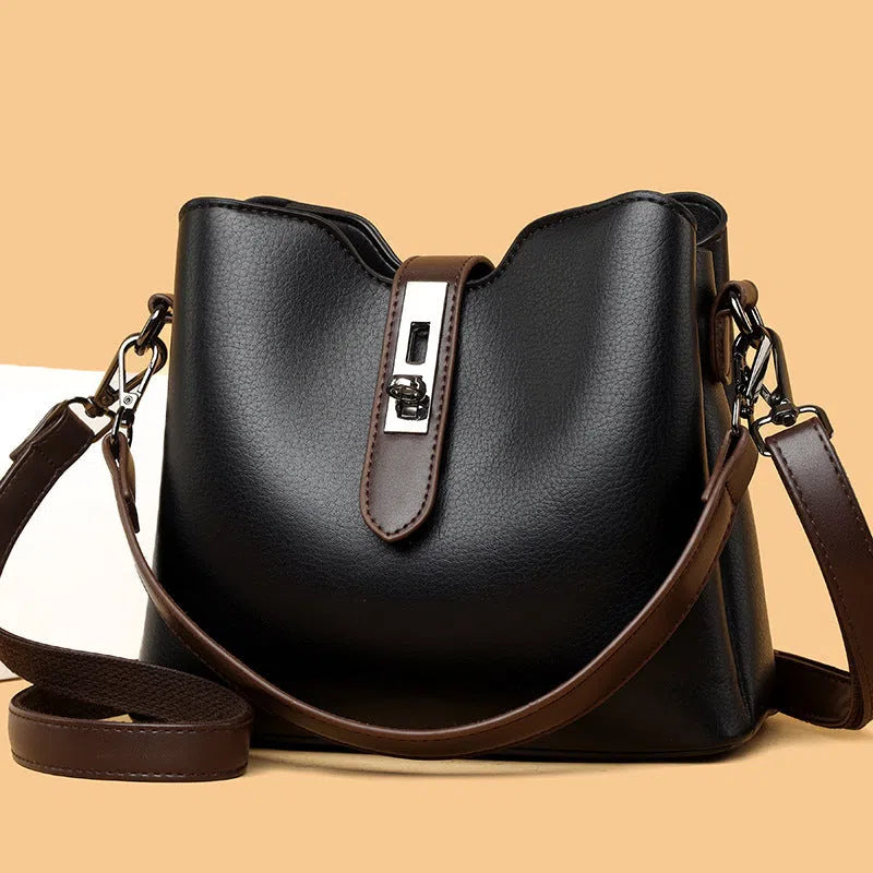Textured PU bucket bag in black with patchwork stitching, horizontal rectangular shape, single shoulder strap.