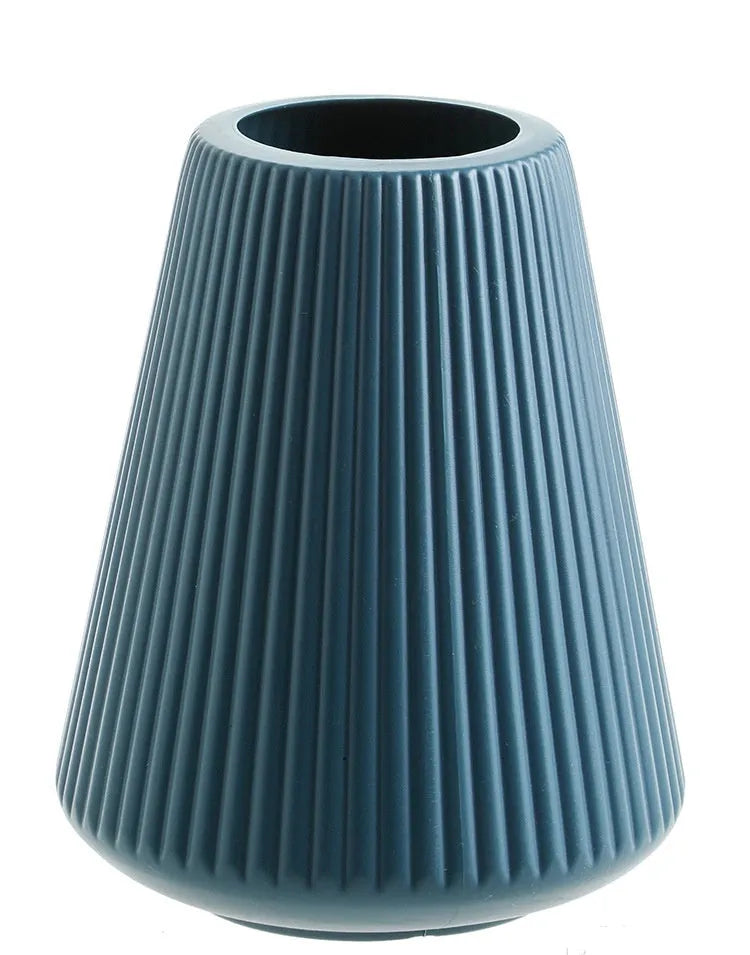 Melamine plastic decorative vase in blue colour on desktop with floral arrangement