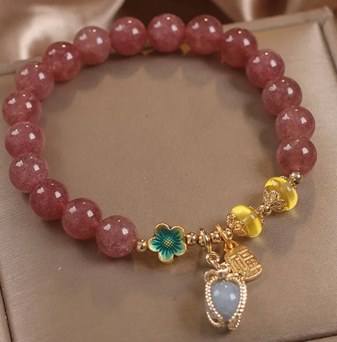 Natural strawberry quartz beaded bracelet red alloy with rhinestone details on white background