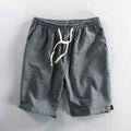 Man wearing black and white striped casual cotton shorts with a loose straight leg fit.