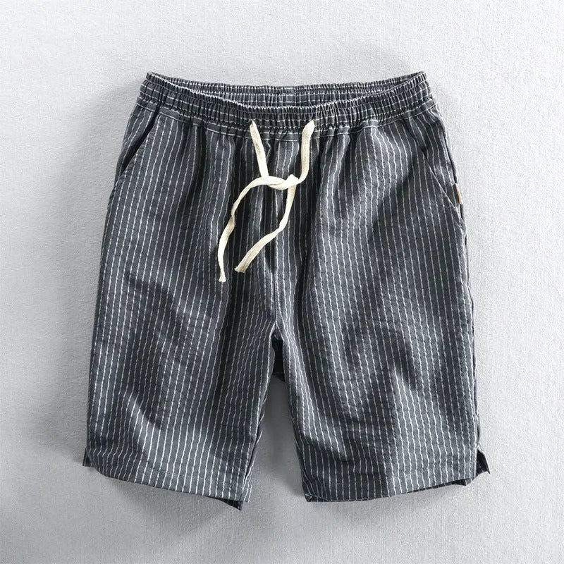 Man wearing black and white striped casual cotton shorts with a loose straight leg fit.