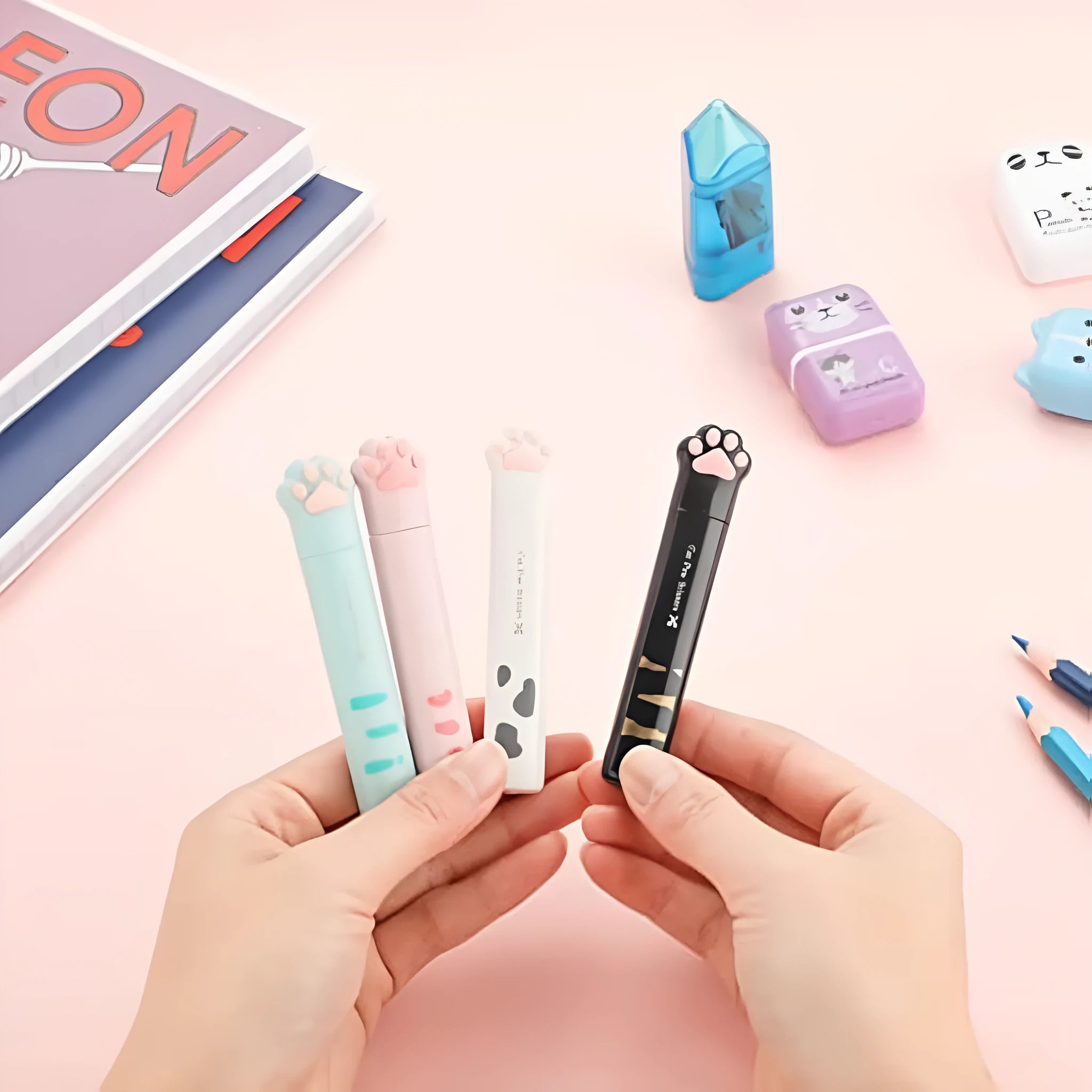 Small folding scissors with cat paw design on handles in choice of four colours, shown with blades safely closed.