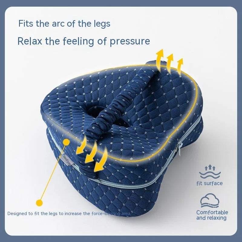 Heart-shaped dark blue jacquard memory foam leg pillow for adults on a bed.