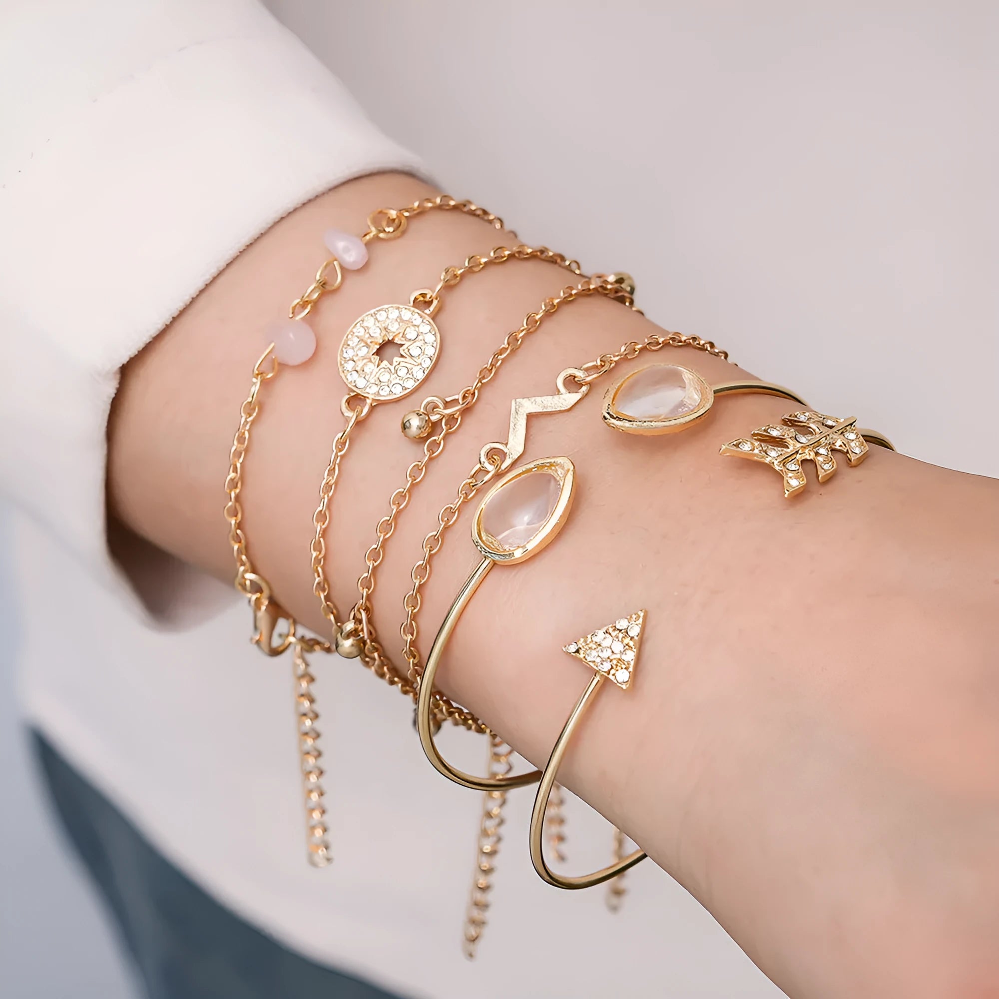 Six gold zinc alloy bracelets with V-shaped, water droplet, arrow and spot drill designs