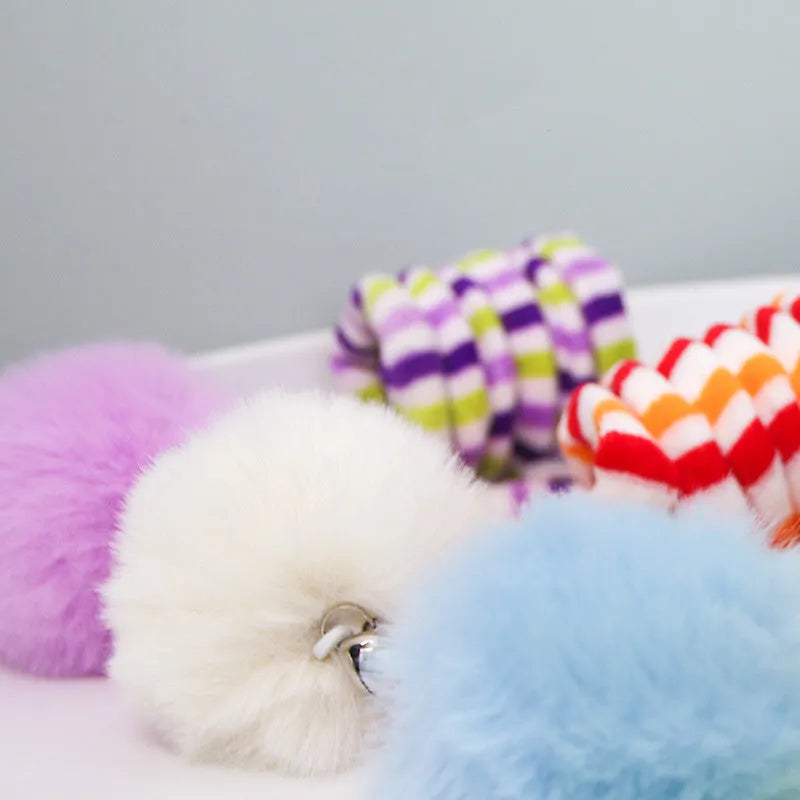 Cat toy with inflatable ball and bell stick hanging from door with suction cup attachment