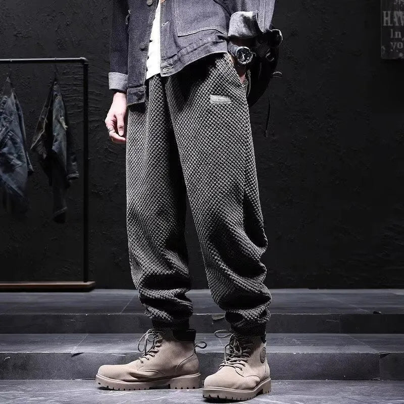 Grey men's straight-leg sweatpants with ankle ties laid flat.