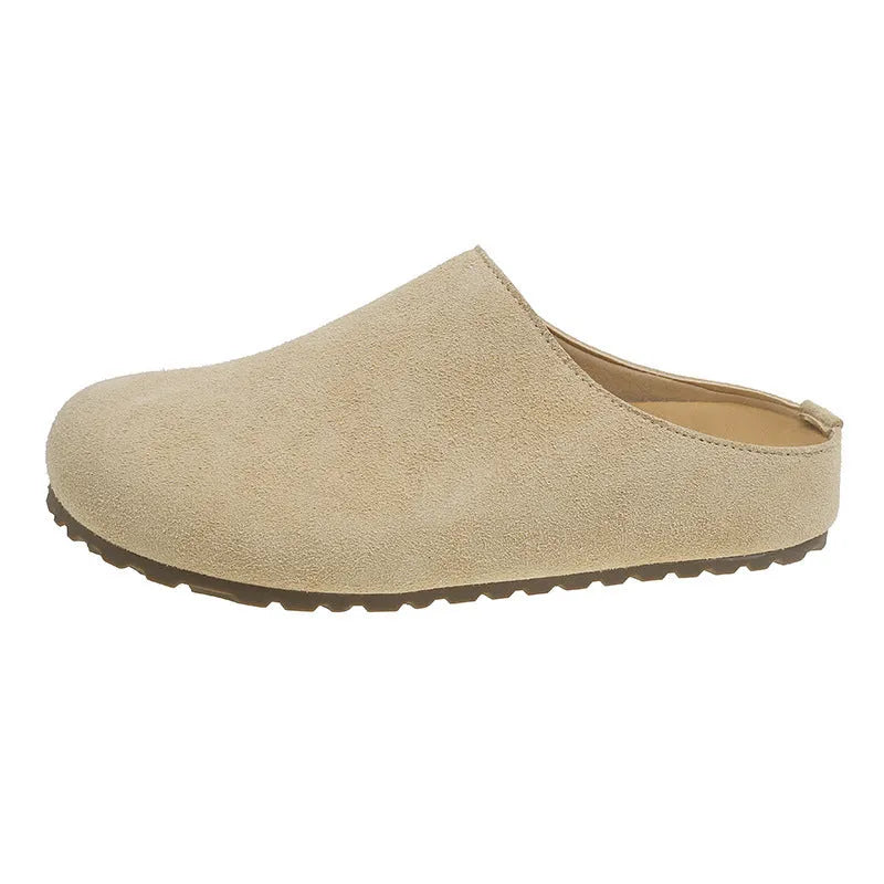 Flat apricot coloured slip-on slippers with a square toe and microfiber upper on a light surface.