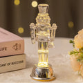 Transparent plastic walnut soldier Christmas nutcracker ornament on a desk.