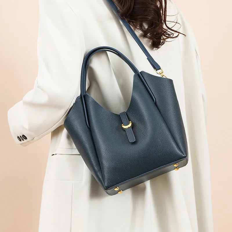Genuine leather women's hand holding bucket bag in European American retro style with visible sewing thread detailing