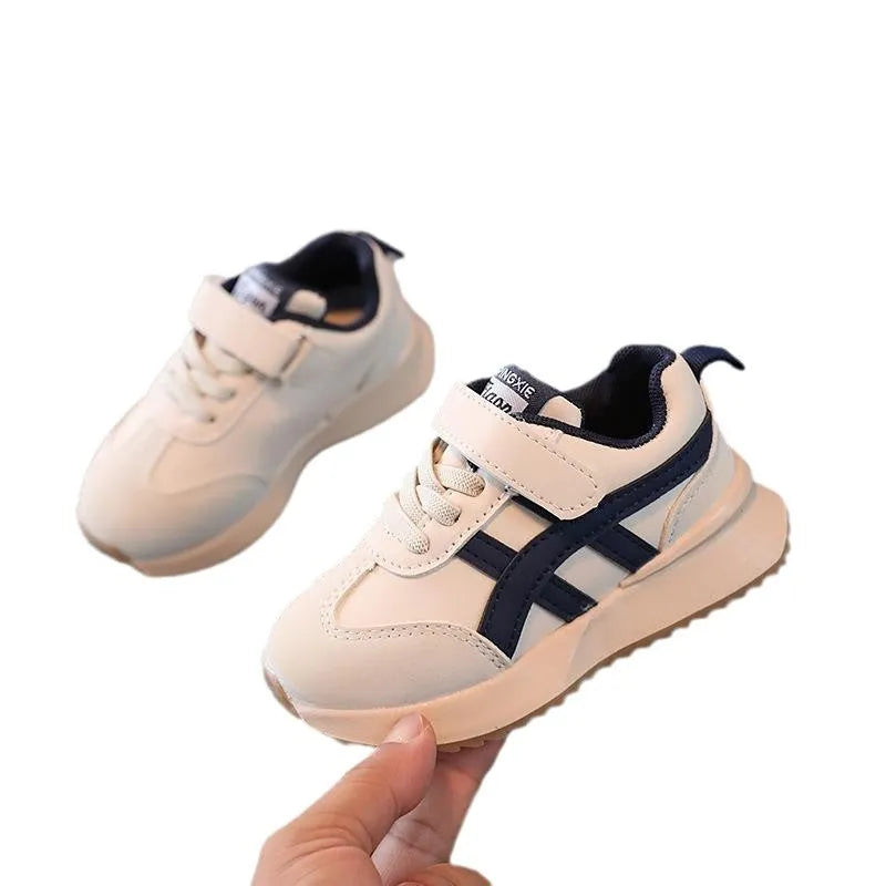 Children's white casual sneaker with Velcro closure showing synthetic leather upper and rubber sole