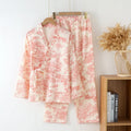 Women's pink pure cotton gauze suit with long sleeves and lace-up trousers on a hanger.
