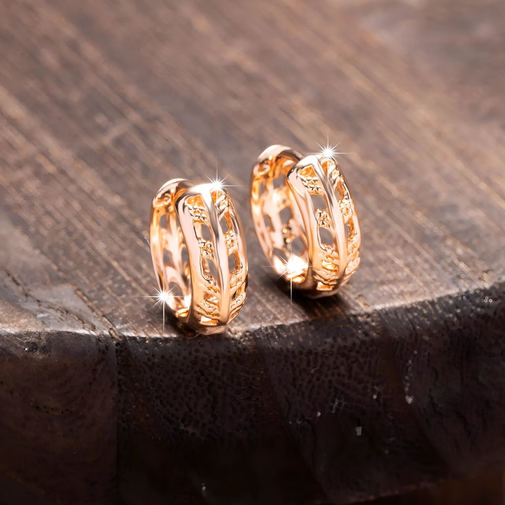 Rose gold hollowed out earrings with heart and leaf shapes on copper background