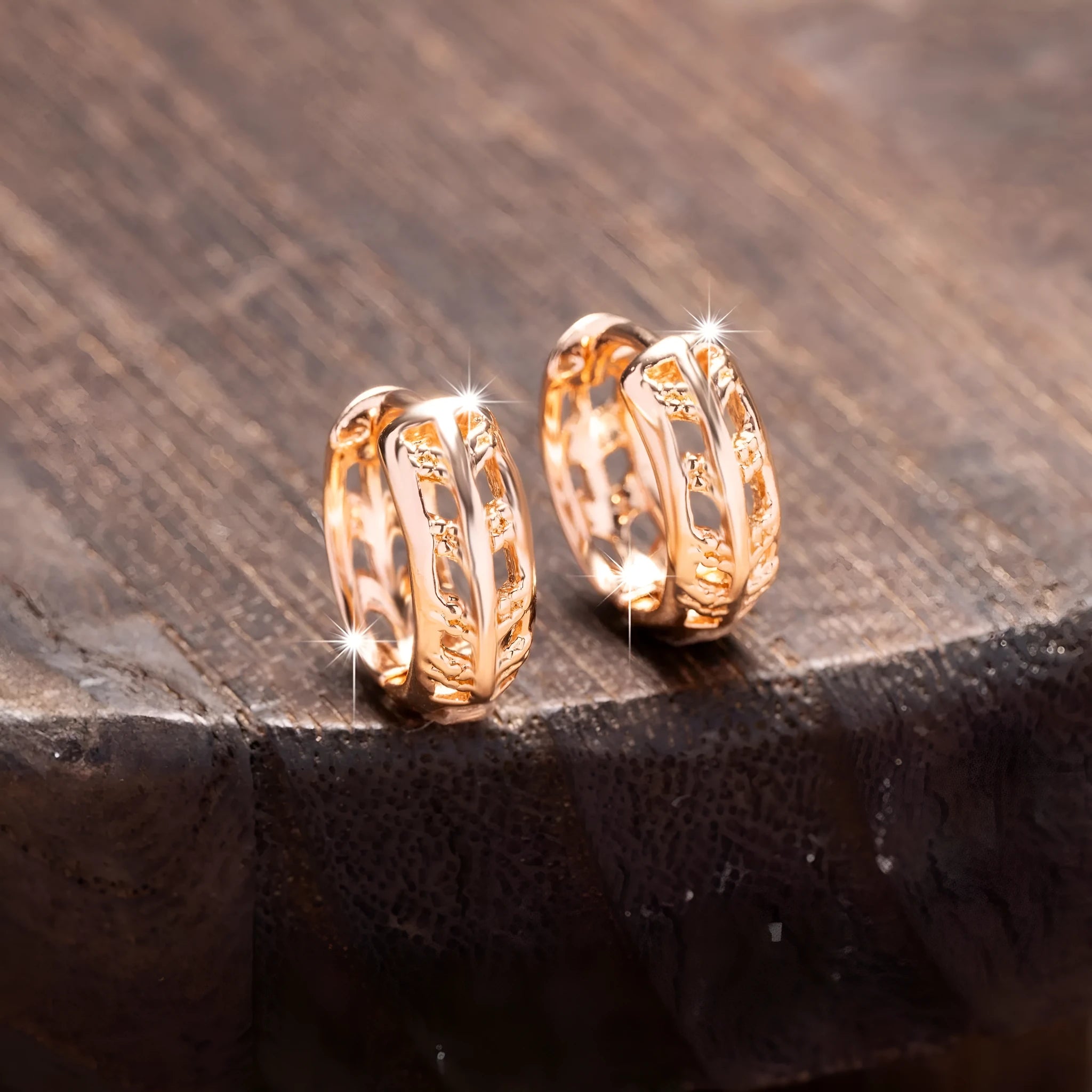 Rose gold hollowed out earrings with heart and leaf shapes on copper background