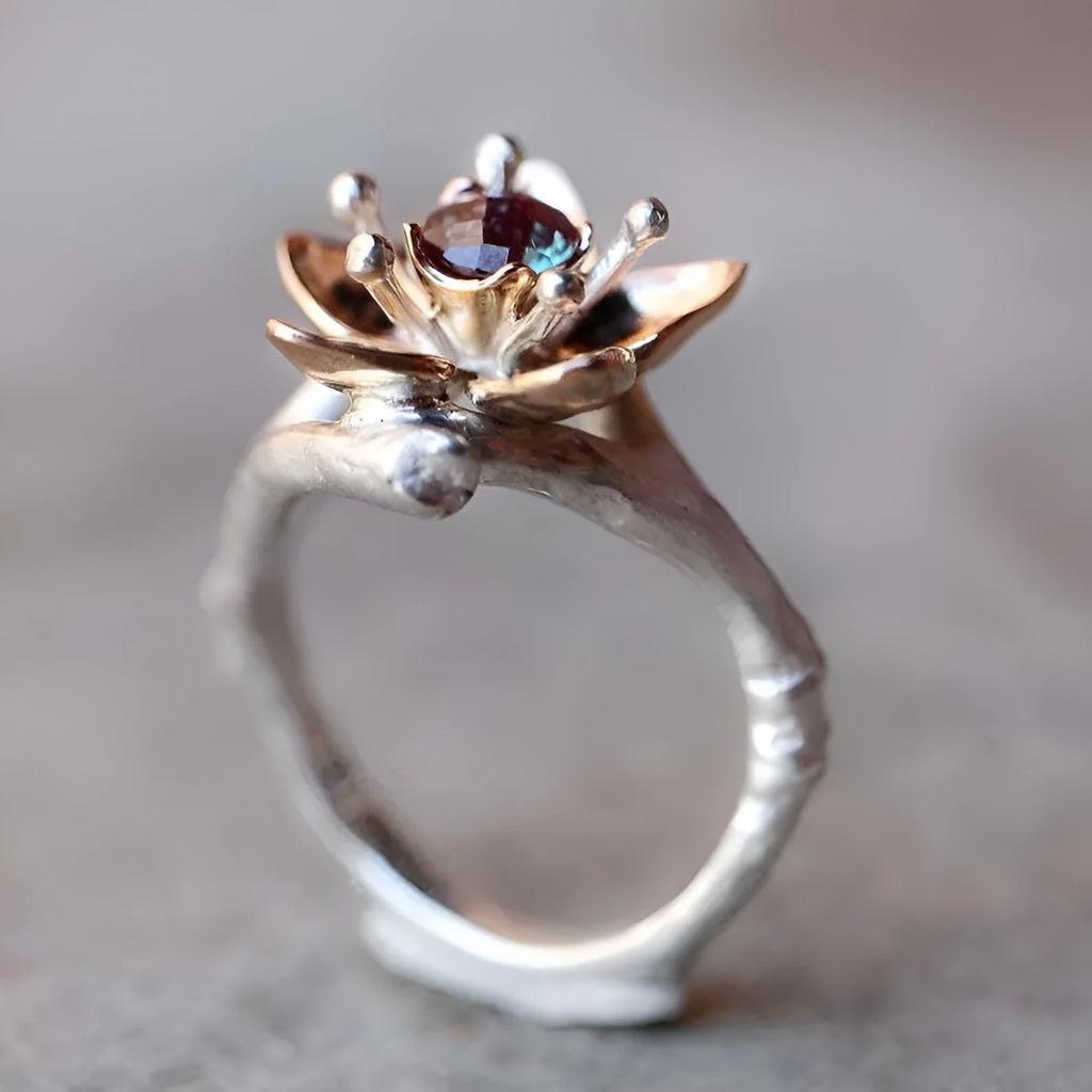Silver two-tone women's ring with a geometric shape and floral design on a grey background