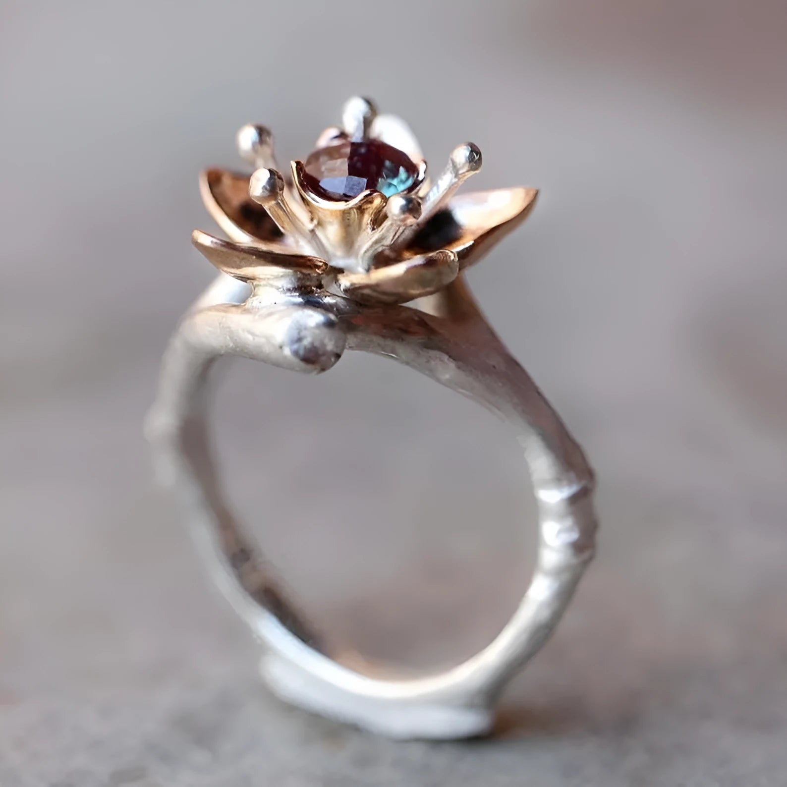 Silver two-tone women's ring with a geometric shape and floral design on a grey background