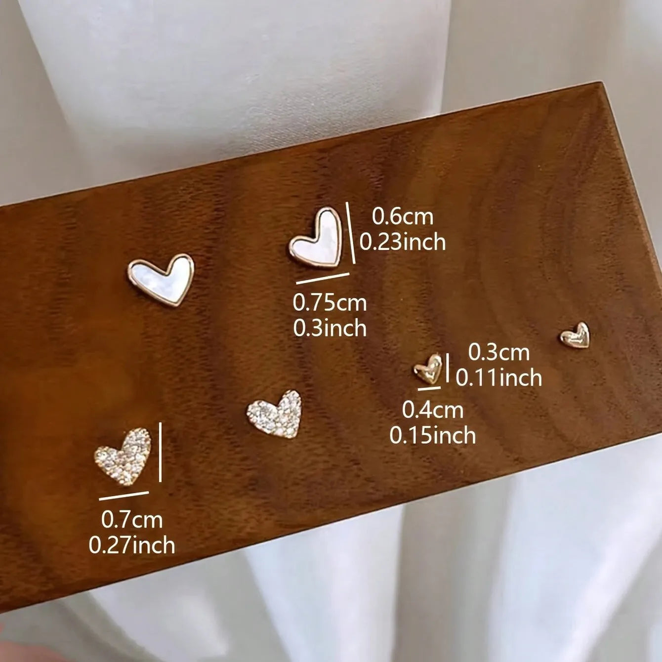 Three pairs of heart-shaped girly drop earrings in gold, black, pink colours