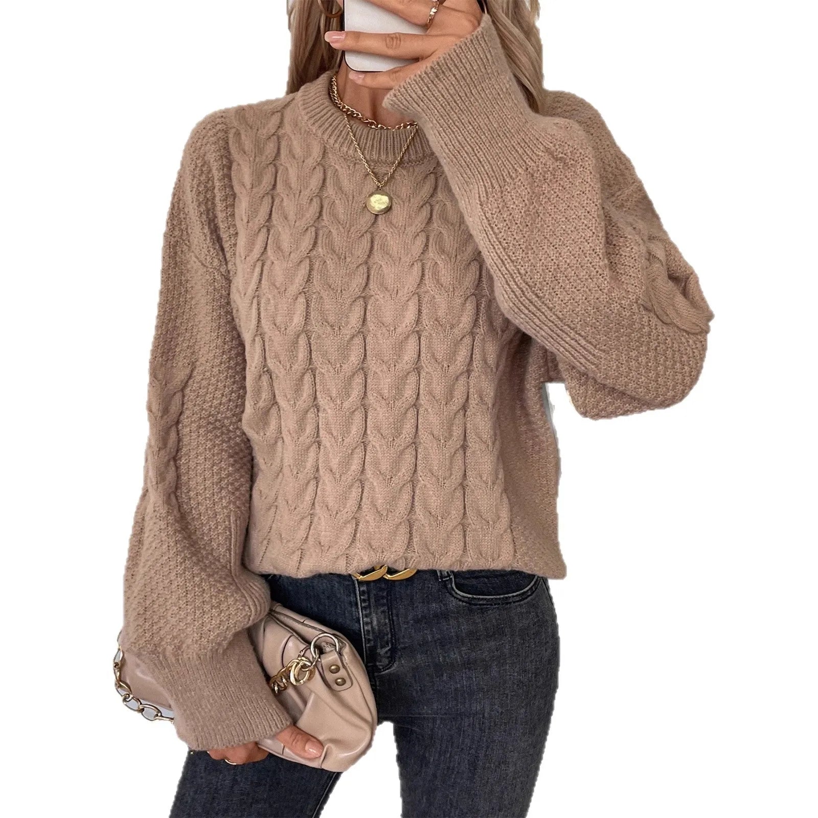 Women's loose beige pullover sweater with a twist detail and round neck on a hanger.