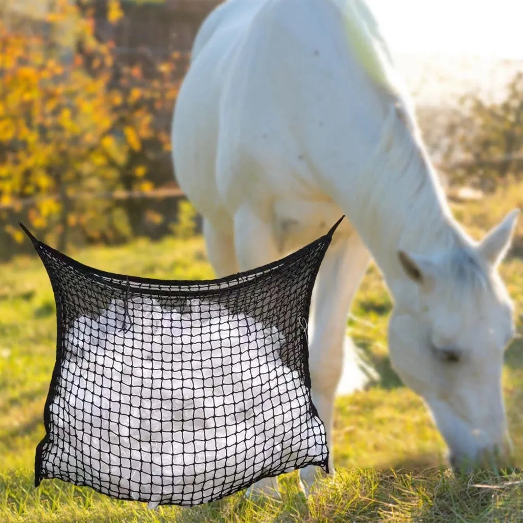 Woven PE rope horse feeding bag with grid pattern in black colour, shown hanging with hay
