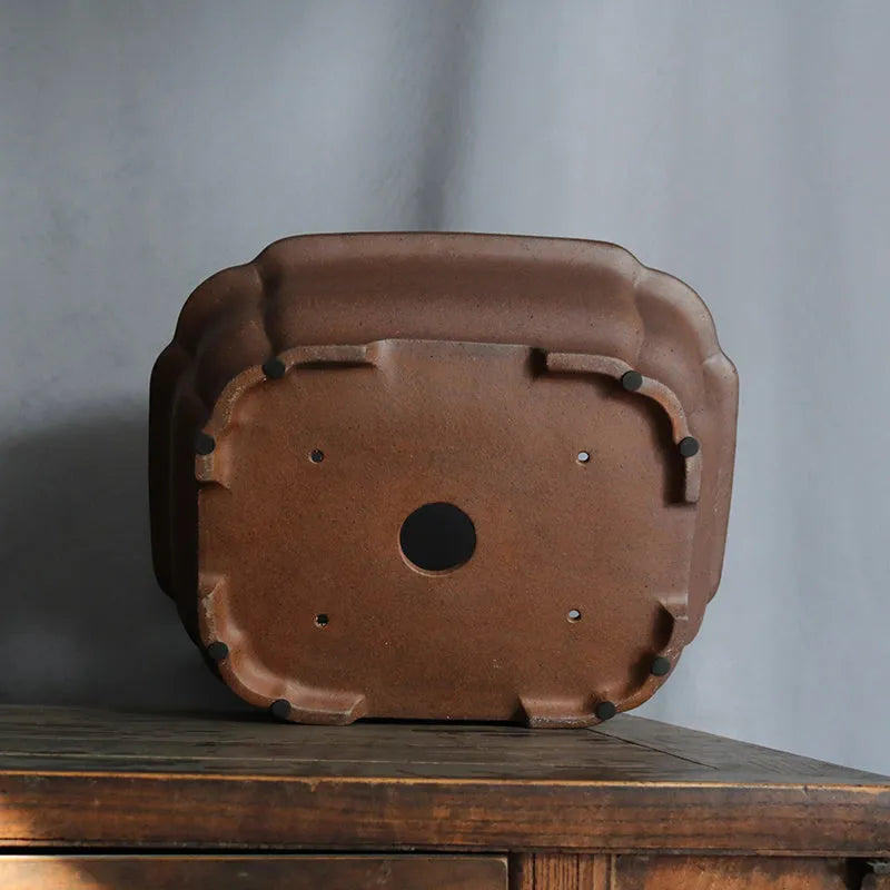 A modern rectangular flower pot made from purple sand ceramic, standing on a floor.