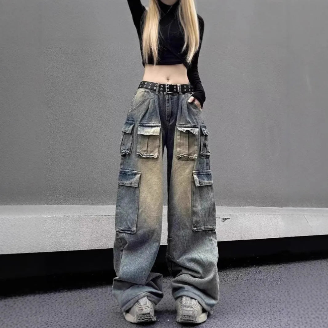 Man wearing loose fit light blue distressed jeans with multiple tooling pockets and straight leg silhouette.