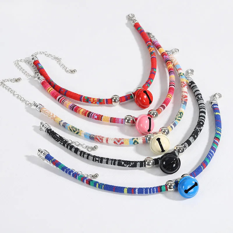 Coloured ethnic pattern adjustable pet collar for dog or cat with a small metal bell attached.