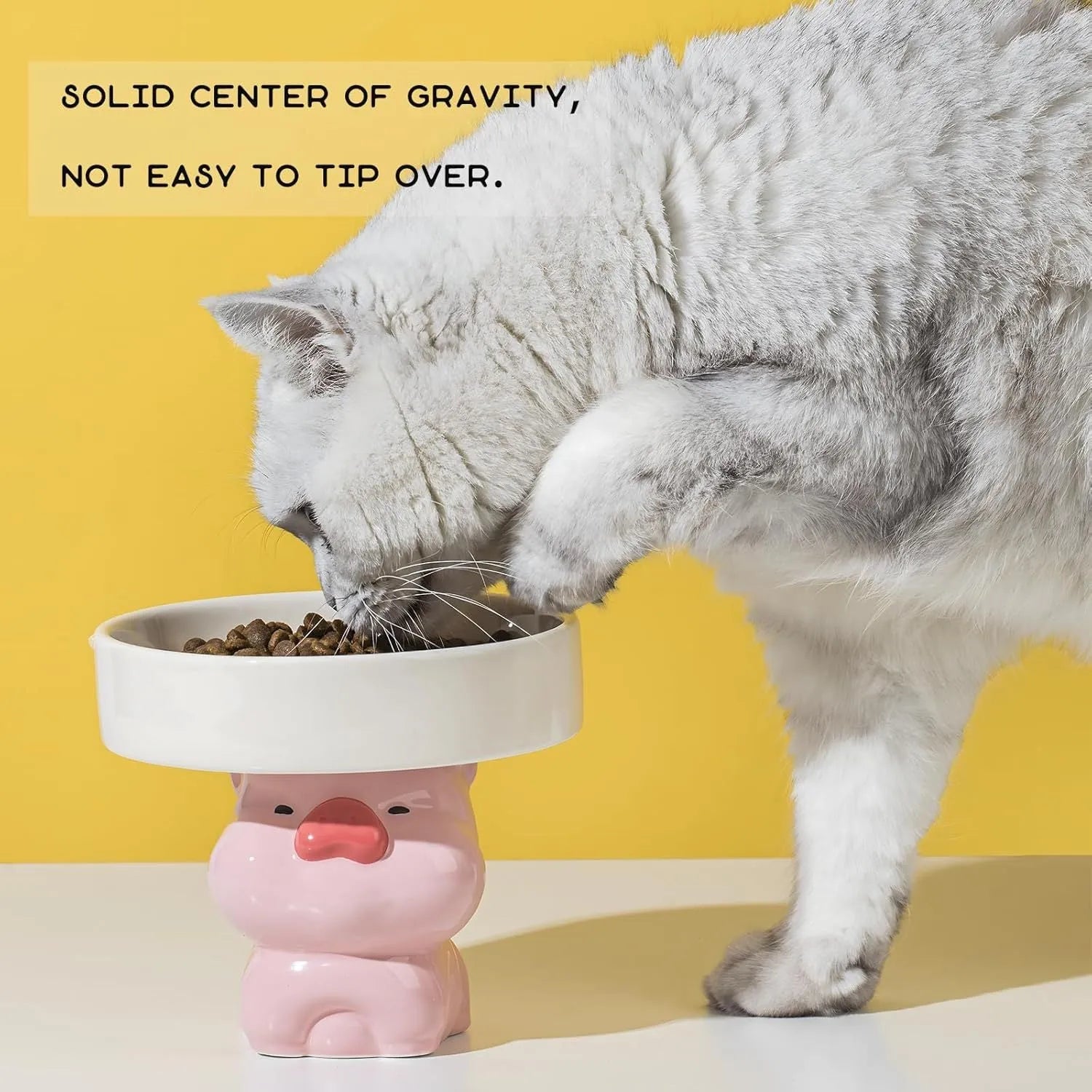 Raised ceramic cat bowl with animal design in pink, yellow, or white, showing wide feeding surface and elevated base.