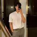 Man wearing a thin black slim-fit knitted short-sleeved shirt.