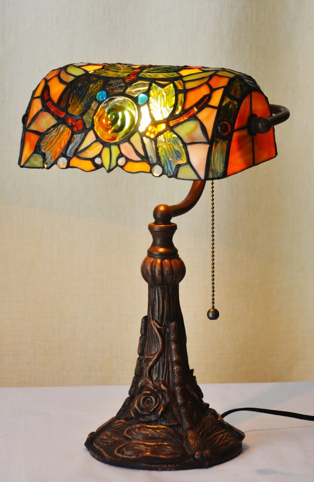 10-inch Tiffany desk lamp with coloured stained glass shade and resin base on a wooden table.