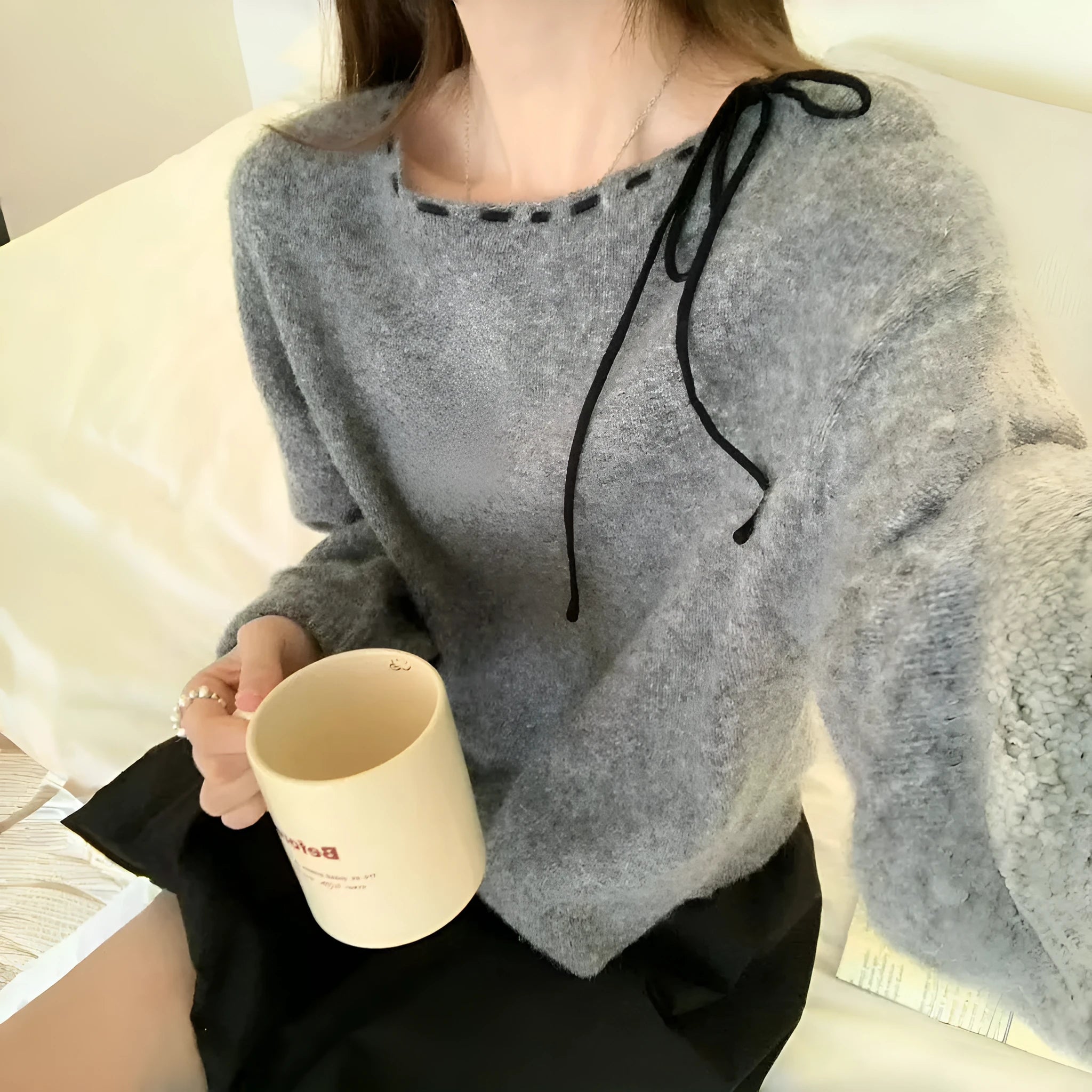 Women's loose-fitting grey knitwear pullover top with long sleeves on a hanger