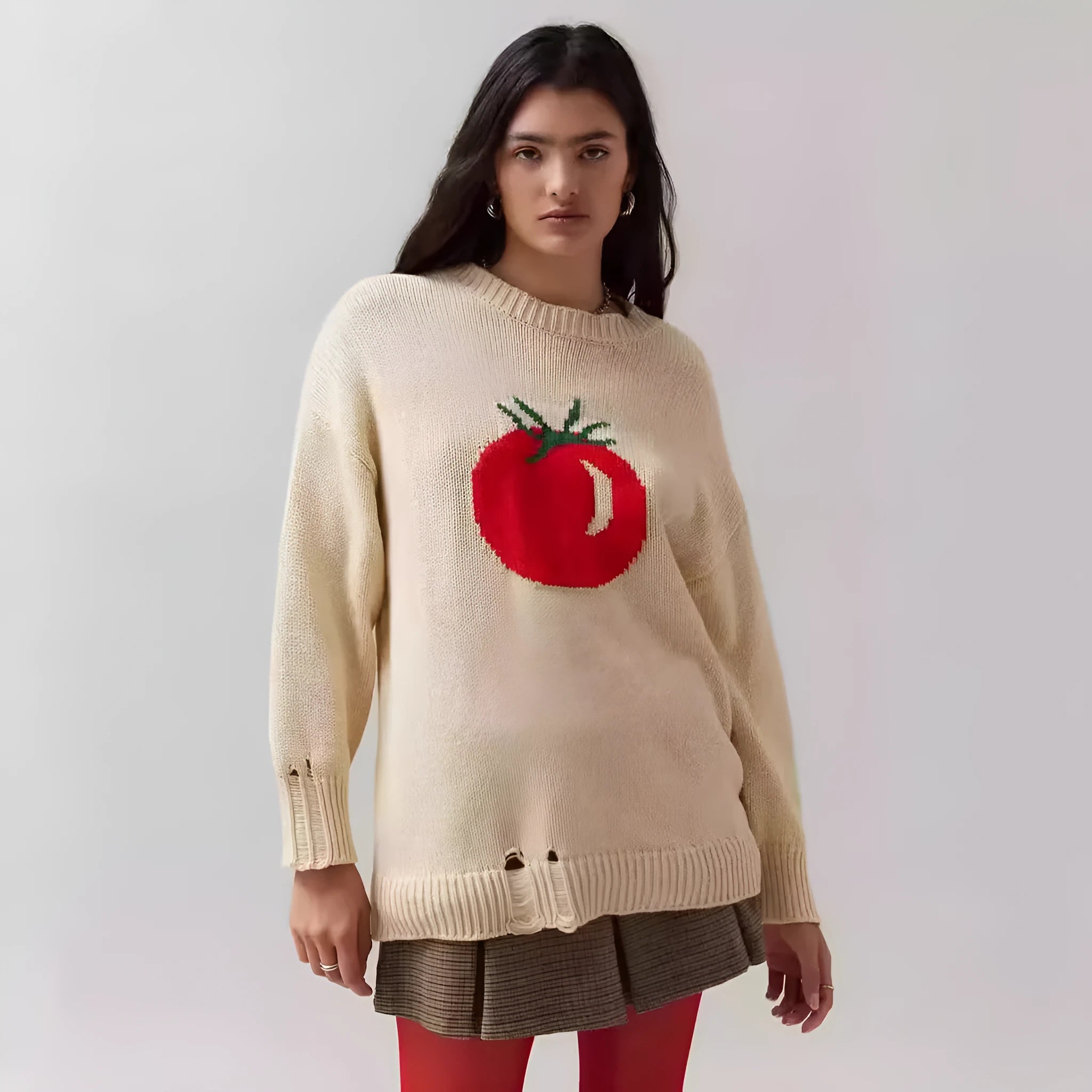 Women's loose-fitting beige jacquard knit sweater on a hanger, showing round neck and long sleeves.