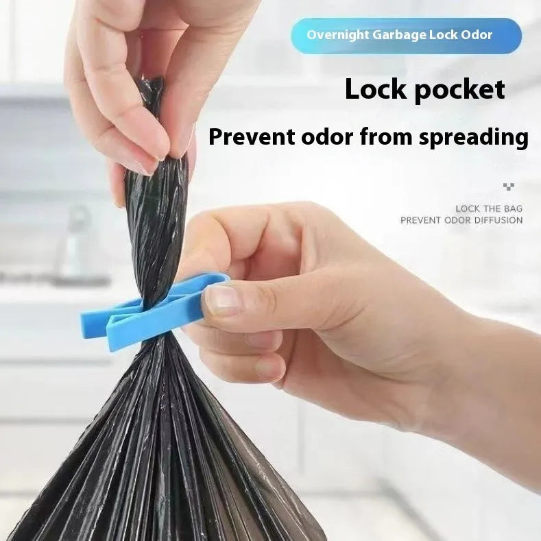 A white polypropylene garbage bag fixing clip holding a black bin liner to the rim of a metal trash can.